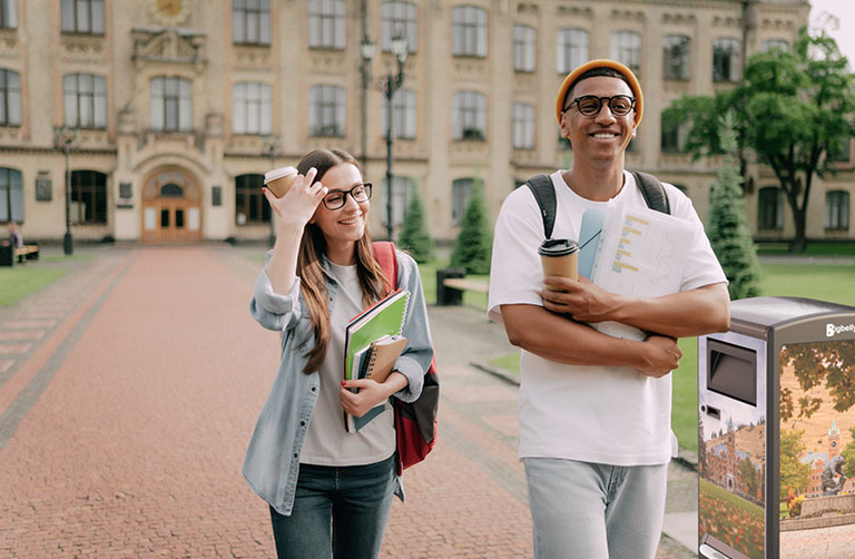 college students walking on a clean campus near a solar trash can